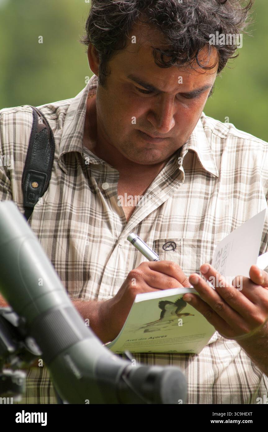 Birdwatcher touriste prenant des notes pendant l'observation des oiseaux aux Açores, Portugal. Banque D'Images