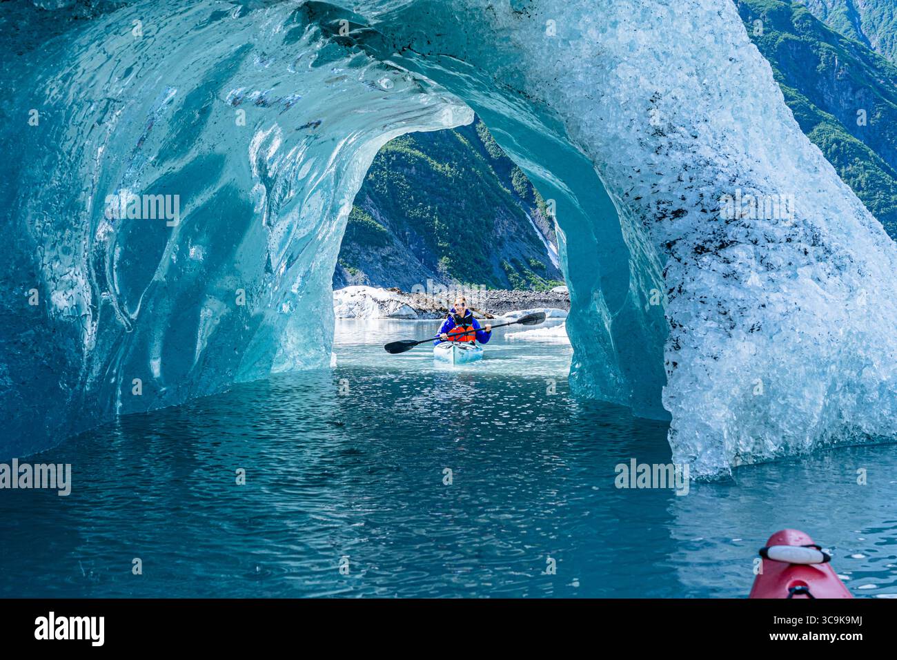 Un kayakiste découvre l'aventure en explorant les grottes glaciaires du lac du glacier Valdez, en Alaska. La merveille de la nature est en plein écran. Banque D'Images