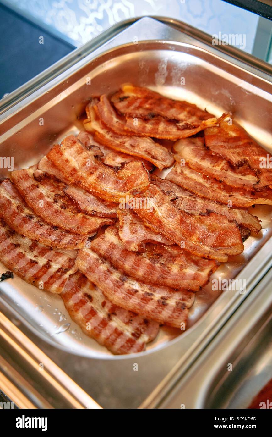Un délicieux plateau de bacon croustillant offrant une saveur et un arôme irrésistibles, parfait pour le petit déjeuner ou toute occasion, soulignant son texture brun doré Banque D'Images