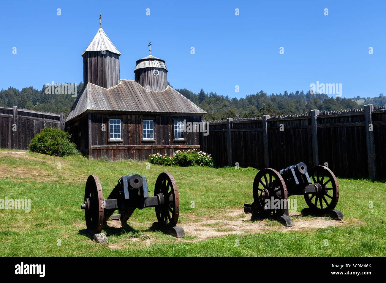 Deux obusiers de 5½ pouces montés sur des affûts de campagne se dressent devant la chapelle orthodoxe russe reconstituée du Fort Ross State Historic Park. Banque D'Images