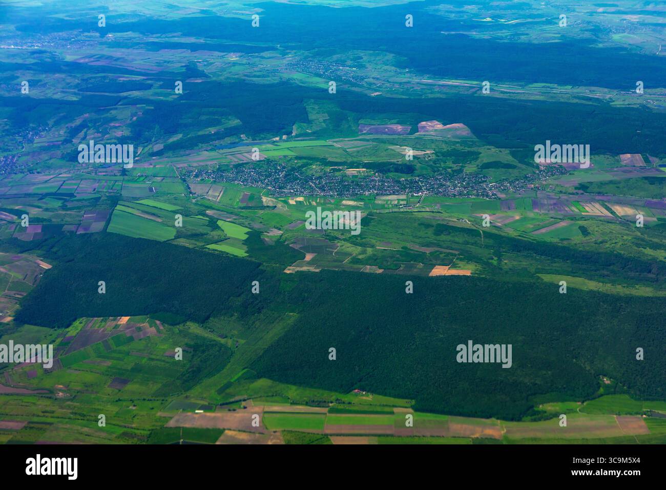Les champs verdoyants et les forêts créent une vue magnifique du paysage d'en haut. Patchwork de champs verts et de forêts, parsemé de petits villages, s'étire Banque D'Images