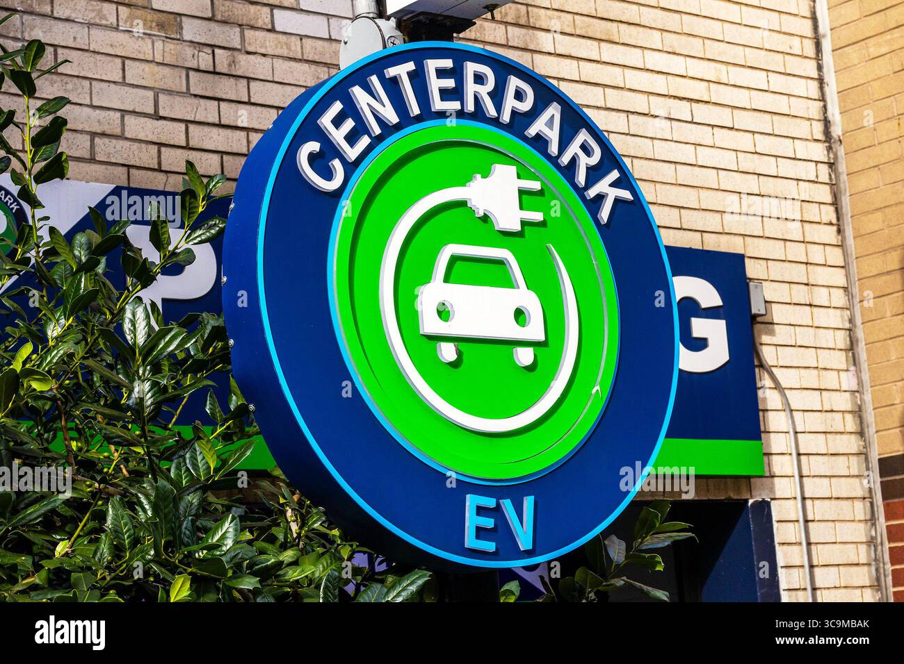 Panneau de stationnement Centerpark EV, logo Centerpark devant un garage de stationnement à New York, icône d'une voiture entourée d'un câble de recharge, véhicule électrique Banque D'Images