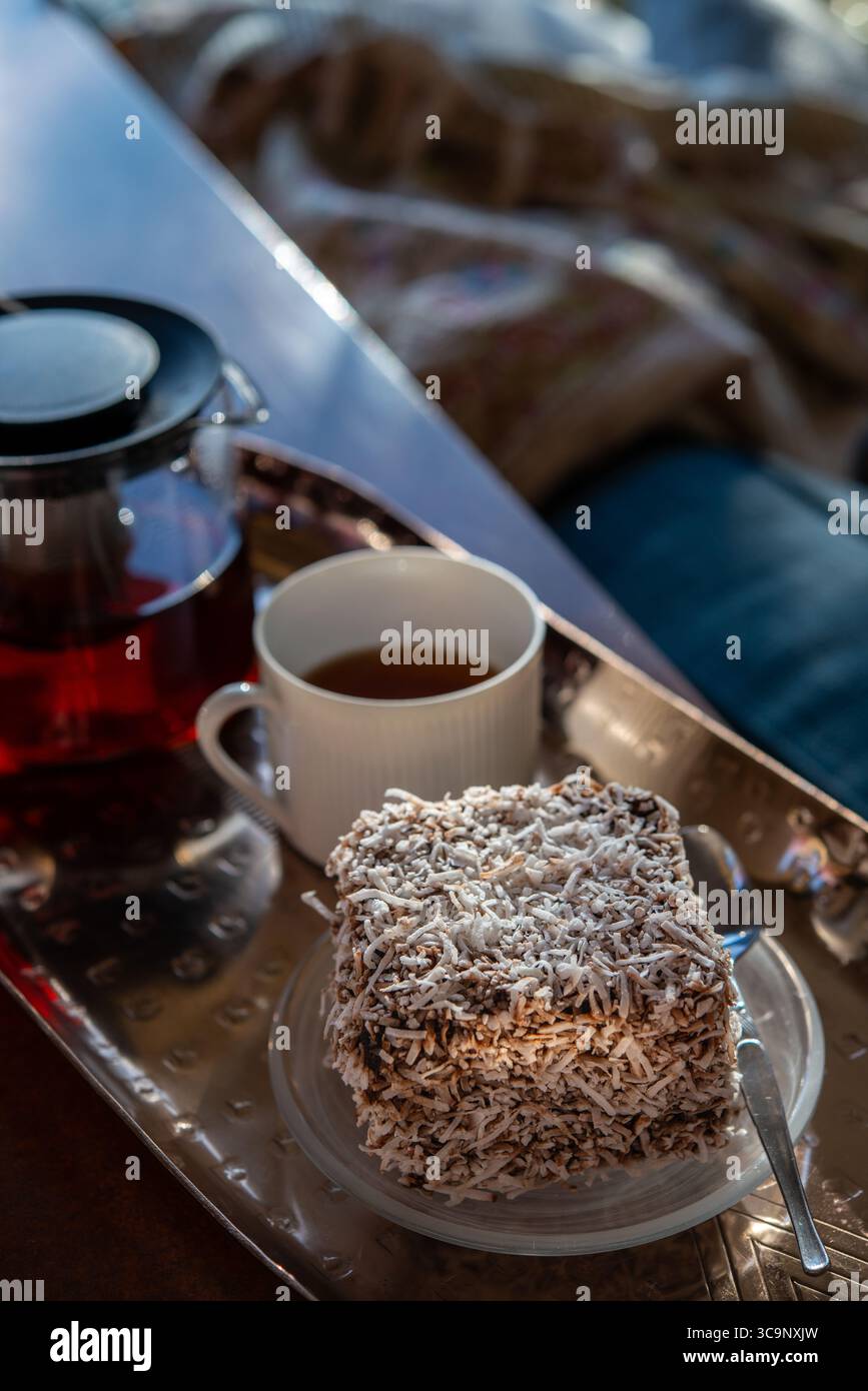 Un gros plan légèrement décentré d'un délicieux gâteau lamington australien, recouvert d'une généreuse couche de noix de coco desséchée Banque D'Images