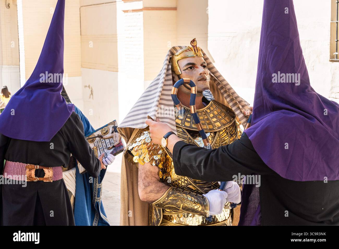 7 avril 2023, Puente Genil, Cordoue, Espagne : Nazaréens portant des chapeaux coniques ajustent le costume d'un personnage biblique habillé en pharaon lors d'une procession du vendredi Saint, dans le cadre de la semaine Sainte ou Semana Santa, le 7 avril 2023 à Puente Genil, Espagne. La ville a une célébration inhabituelle avec une procession de toutes les figures bibliques depuis 1661. (Crédit image : © Richard Ellis/ZUMA Press Wire) Banque D'Images