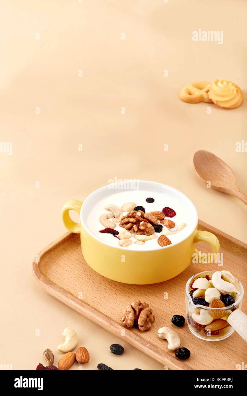 Délicieux et sain bol de noix et graines mélangées avec yaourt et friandises, petit déjeuner sain avec muesli, noix et brioches. Banque D'Images