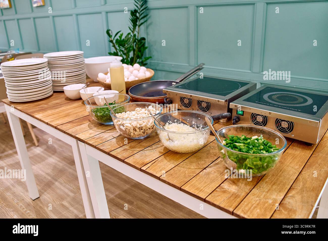 Un comptoir de cuisine bien éclairé affichant les ingrédients et l'équipement de cuisson pour la préparation des repas dans un environnement culinaire confortable Banque D'Images
