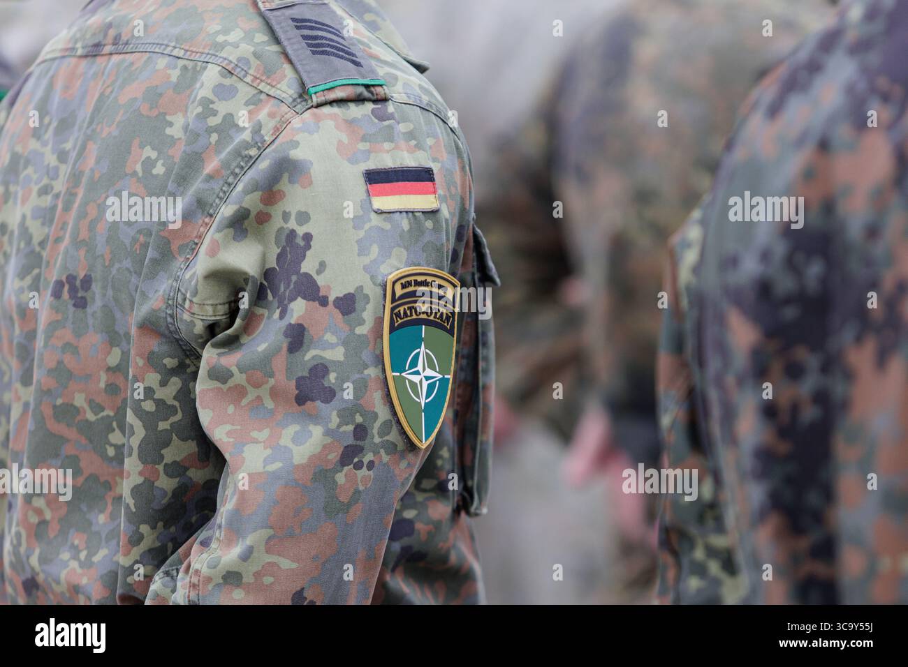 Soldat allemand en uniforme de camouflage flecktarn avec écusson d'épaule OTAN OTAN OTAN OTAN et badge de drapeau allemand debout en formation Banque D'Images