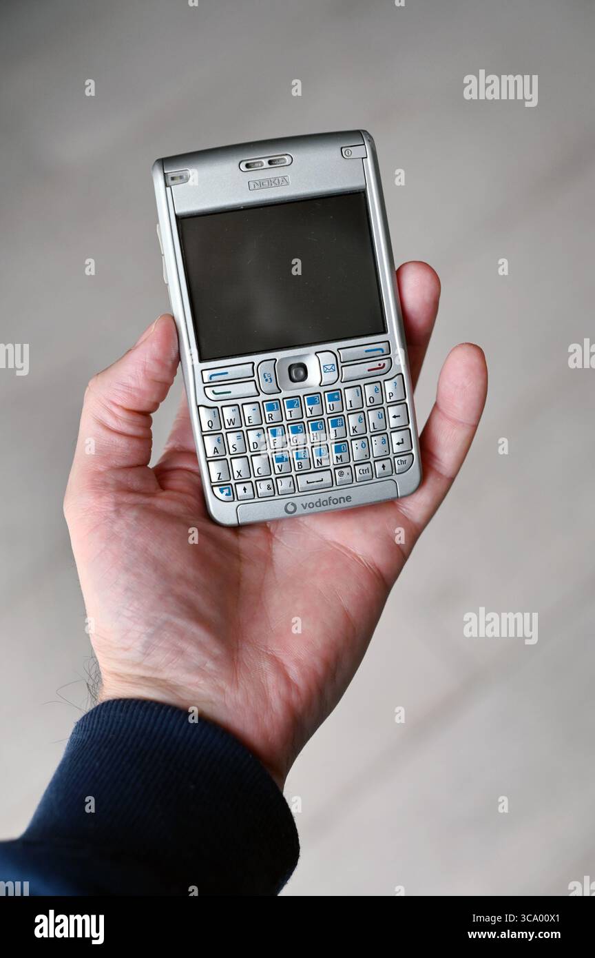 Milan, Lombardie, Italie - 10 février 2025 : main présentant un téléphone mobile Nokia E61 vintage, mettant en valeur son design rétro et la marque Vodafone, Highl Banque D'Images