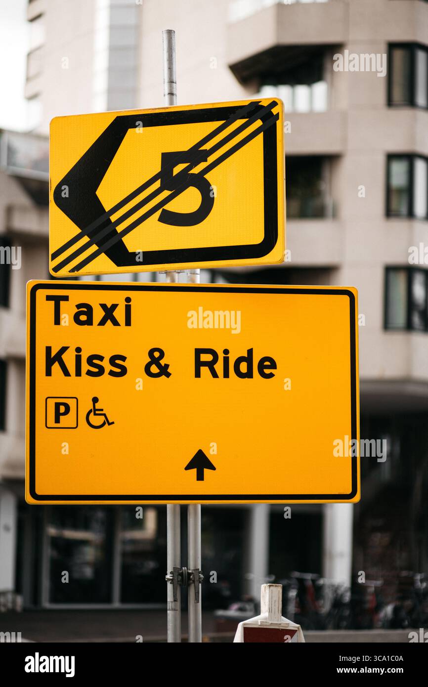 Eindhoven, pays-Bas - juillet 2025 : panneau jaune 'TAXI Kiss and Ride' monté sur un poteau en métal noir. Panneau de stand de taxi urbain. Paramètres de rue de la ville Banque D'Images