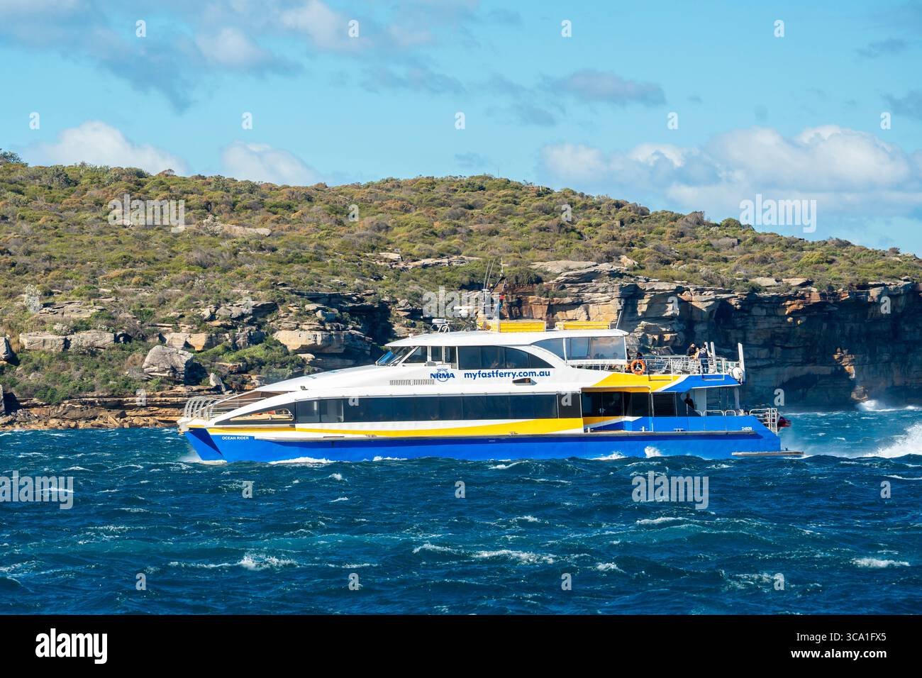 Un NRMA Manly Fast Ferry voyageant par vent de Circular Quay à Manly Wharf par un après-midi d'été ensoleillé à Sydney, en Australie Banque D'Images