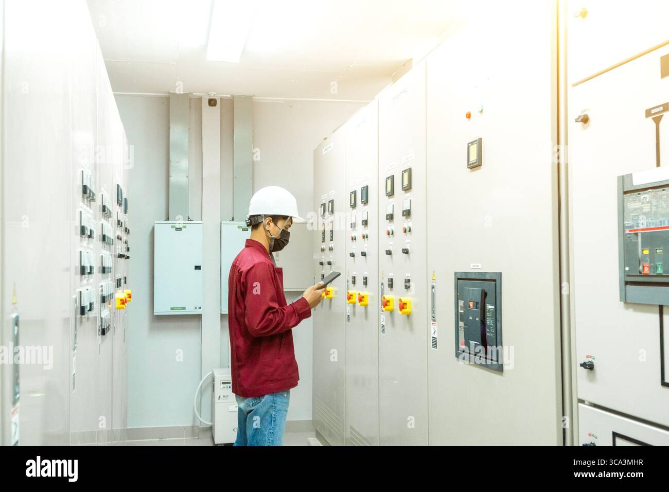 L'ingénieur vérifiant et inspectant au panneau MDB .HE travaillant avec le tableau électrique pour vérifier la plage de tension travaillant dans les tableaux de distribution principaux Banque D'Images