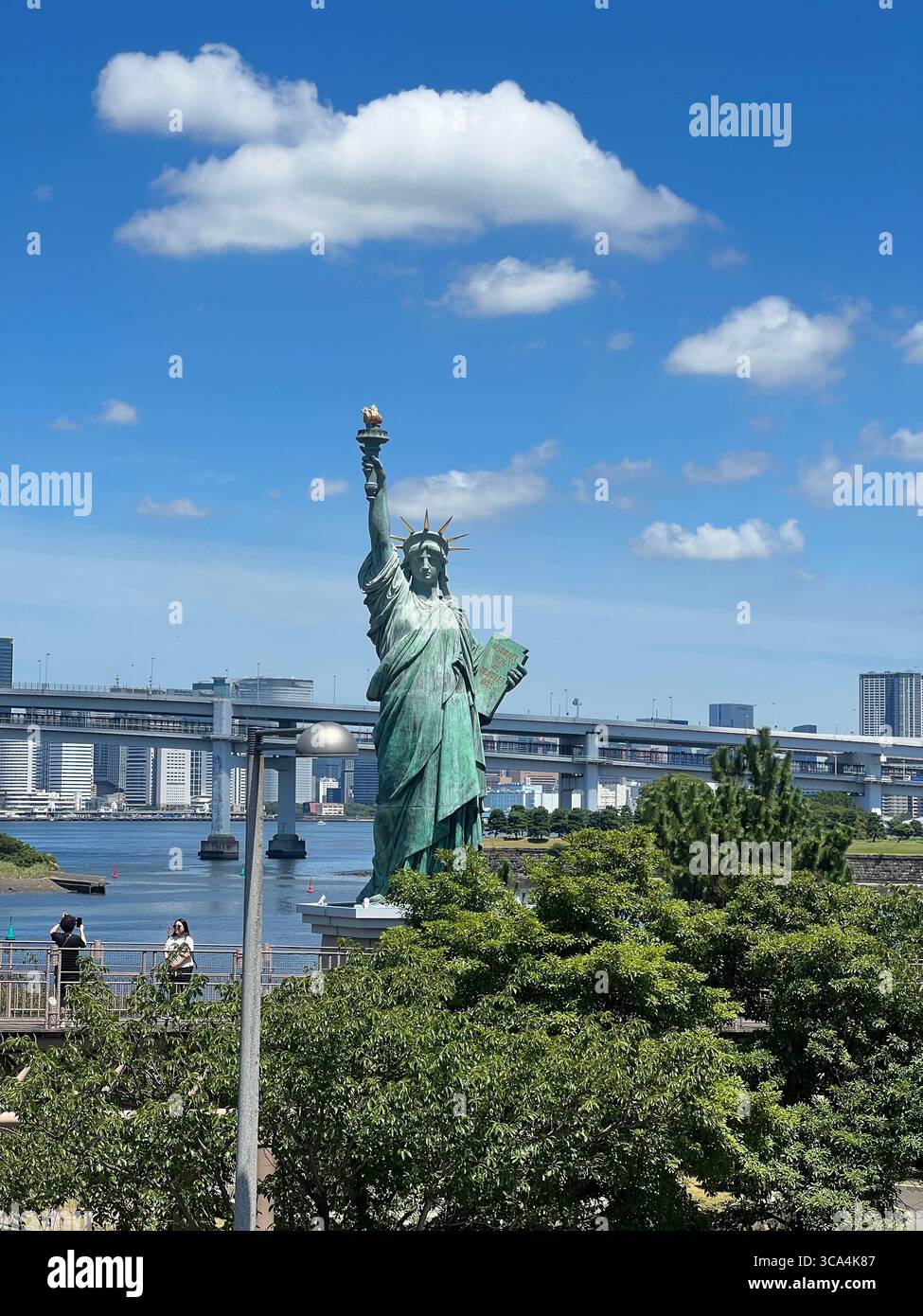 La réplique de la Statue de la liberté se dresse fièrement sur Odaiba, Tokyo, offrant une touche culturelle unique contre les gratte-ciel de la ville. Banque D'Images