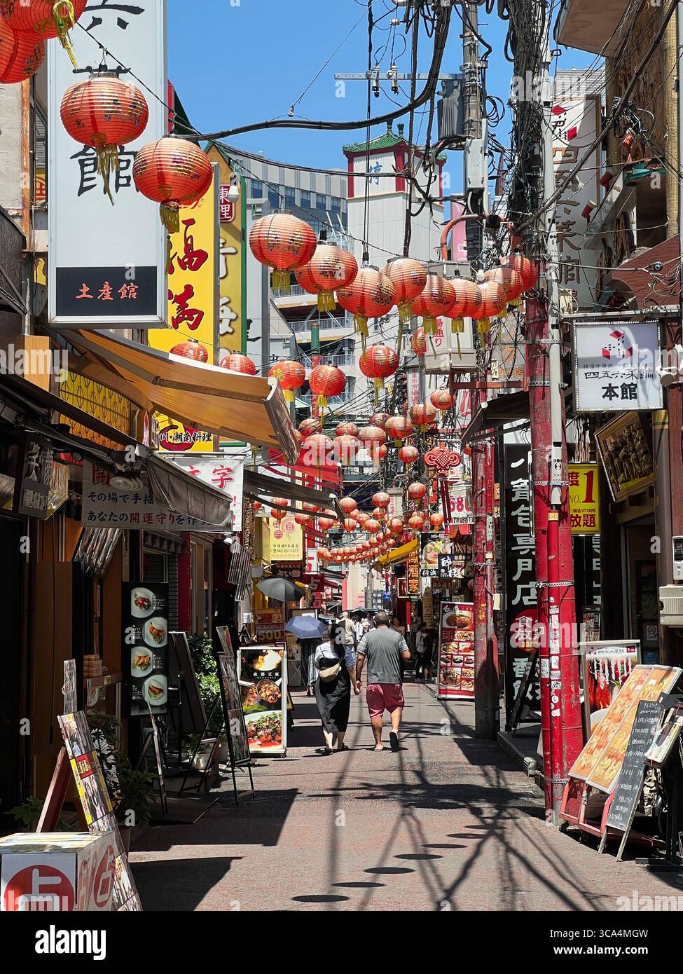 Des lanternes lumineuses et des portes ornées accueillent les visiteurs dans le quartier chinois animé de Yokohama. Banque D'Images