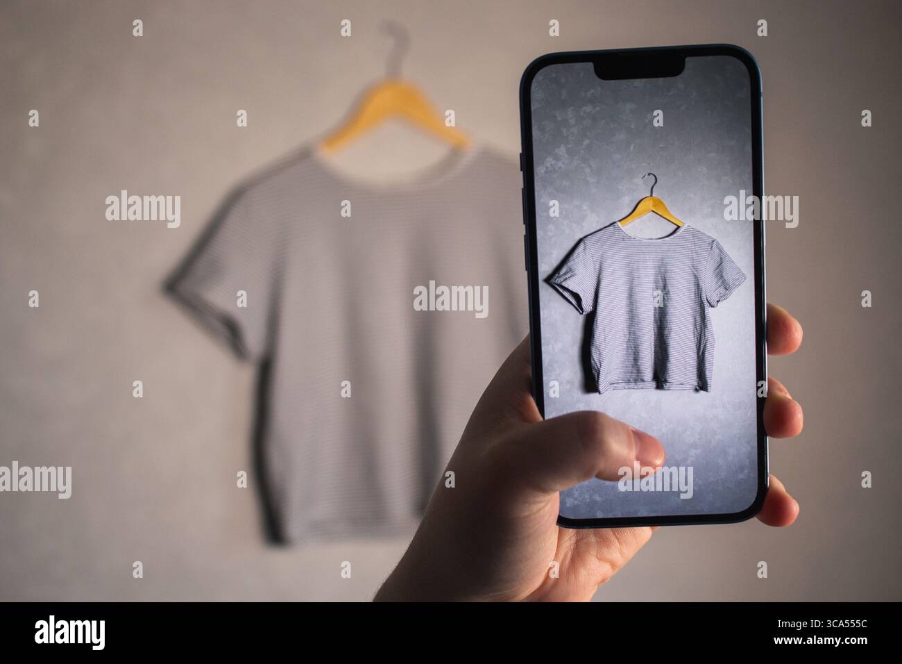 Fille prend des photos de ses vieux articles de garde-robe pour vendre d'occasion. Fond minimaliste. Concentrez-vous sur les habitudes de consommation respectueuses de l'environnement. Banque D'Images Fille prend des photos de ses vieux articles de garde-robe pour vendre d'occasion. Fond minimaliste. Concentrez-vous sur les habitudes de consommation respectueuses de l'environnement. Banque D'Images