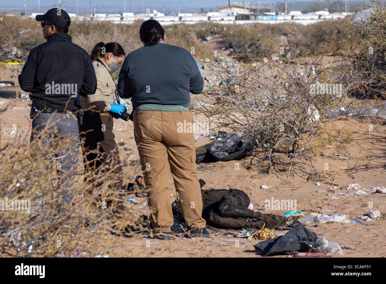 Les forces de l'ordre sondent une scène de crime jonchée de débris à Ciudad Juarez, reflétant la violence urbaine en cours. Banque D'Images