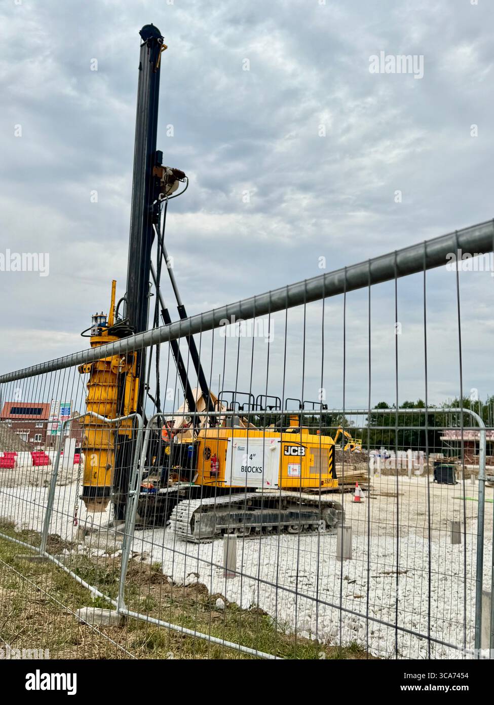 Puissant engin de forage hydraulique sur un chantier de construction de logements, utilisé pour installer des tuyaux. - Image de stock capturée avec un smartphone