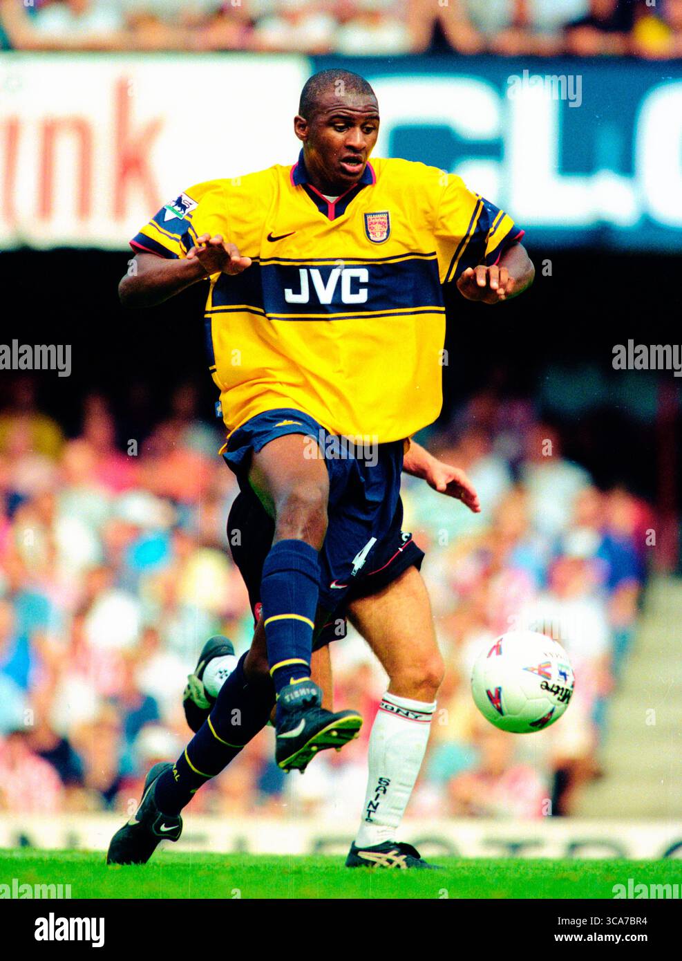 Patrick Vieira en action jouant pour Arsenal dans la saison 1998-99 dans le kit extérieur jaune JVC. Cette image est liée par les restrictions de Dataco sur la façon dont elle peut être utilisée. UTILISATION ÉDITORIALE UNIQUEMENT aucune utilisation avec des fichiers audio, vidéo, données, listes de présentoirs, logos de club/ligue ou services « live » non autorisés. Banque D'Images