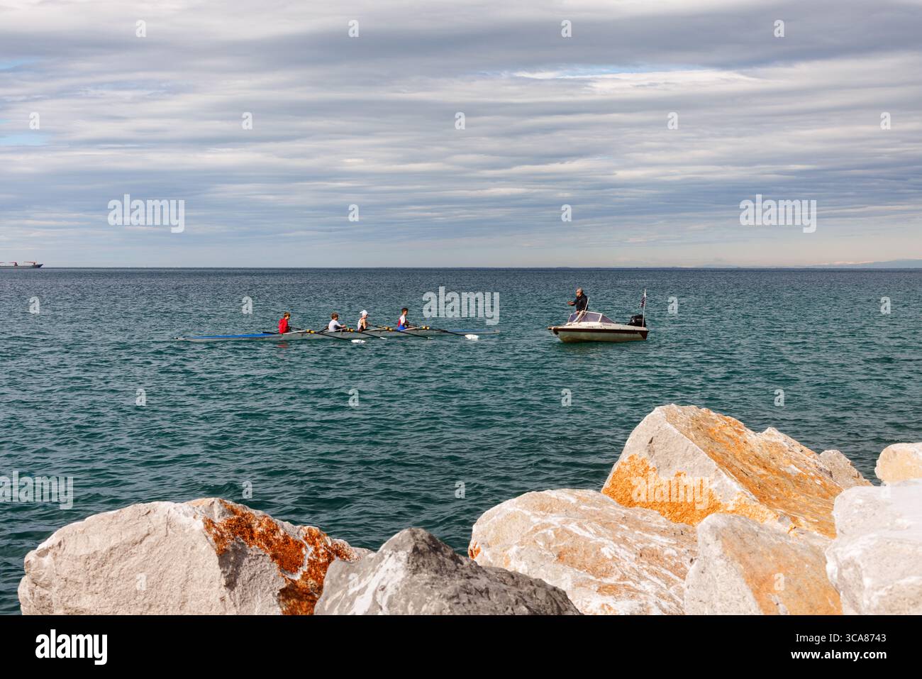 Trieste - Italie - 30 mars 2025 : formation de canoë pour les jeunes sur la mer Adriatique, avec autocar à proximité dans un bateau à moteur donnant des instructions. Concept de mentorshi Banque D'Images Trieste - Italie - 30 mars 2025 : formation de canoë pour les jeunes sur la mer Adriatique, avec autocar à proximité dans un bateau à moteur donnant des instructions. Concept de mentorshi Banque D'Images