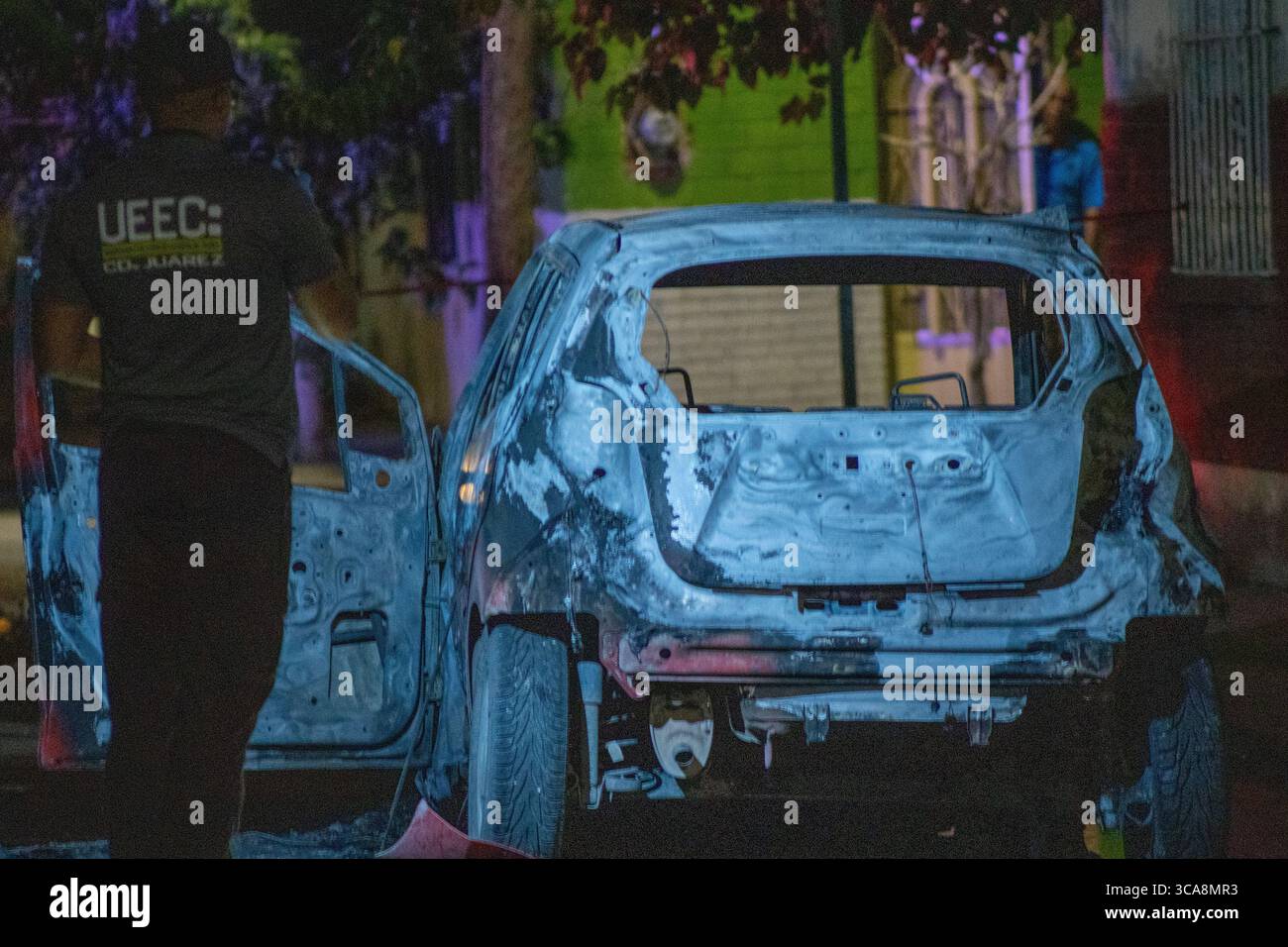 L'enquêteur médico-légal sonde un véhicule carbonisé dans un contexte de flambée de violence dans la ville de Ciudad Juarez. Banque D'Images