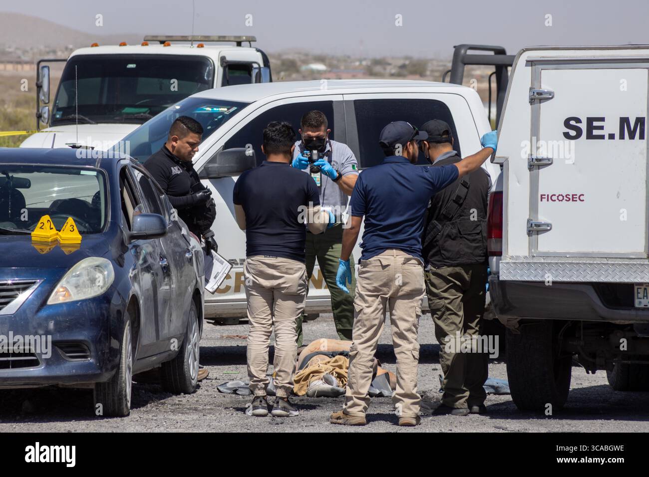 Les policiers enquêtent sur une scène de crime autour d'un véhicule endommagé à Ciudad Juarez, une ville en proie à la violence urbaine. Banque D'Images