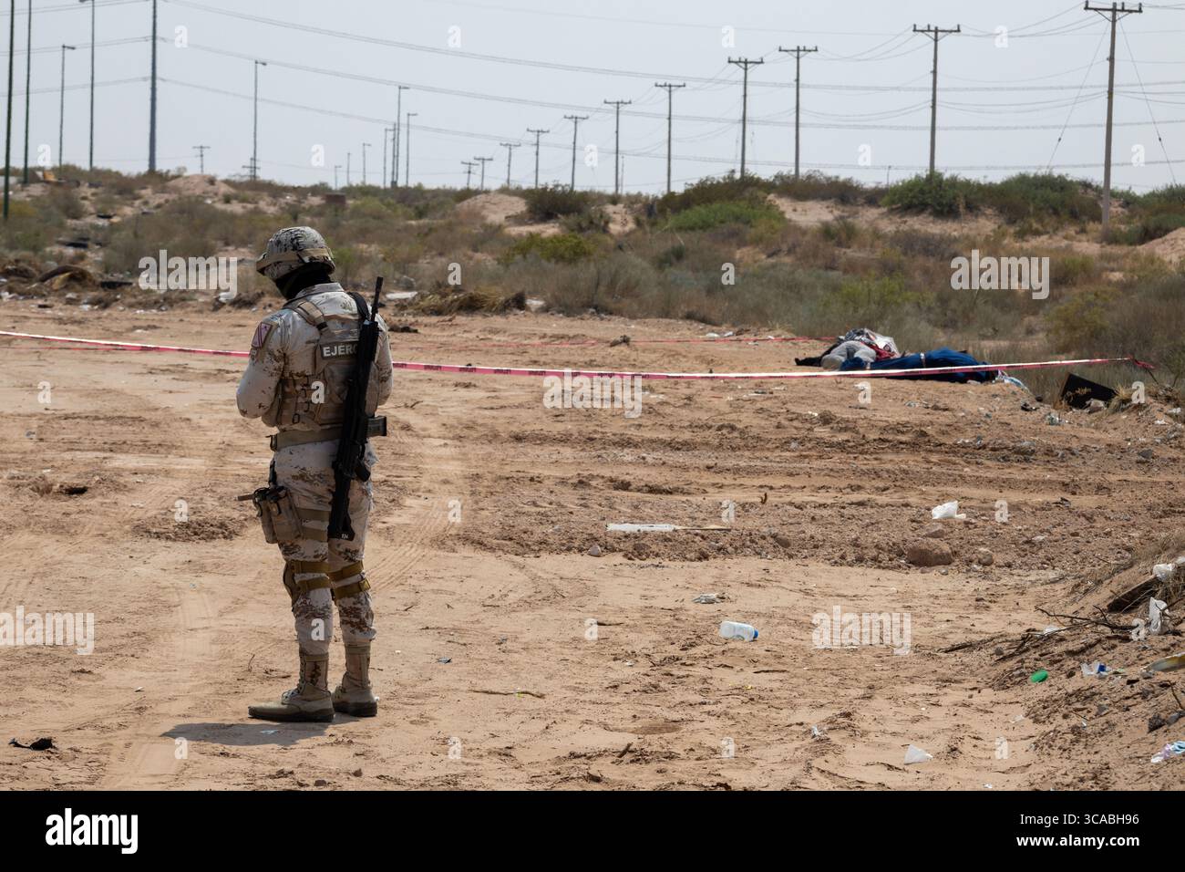 Soldat surveille une scène de crime dans le désert de Ciudad Juarez, reflétant la lutte de la ville contre la violence urbaine. Banque D'Images