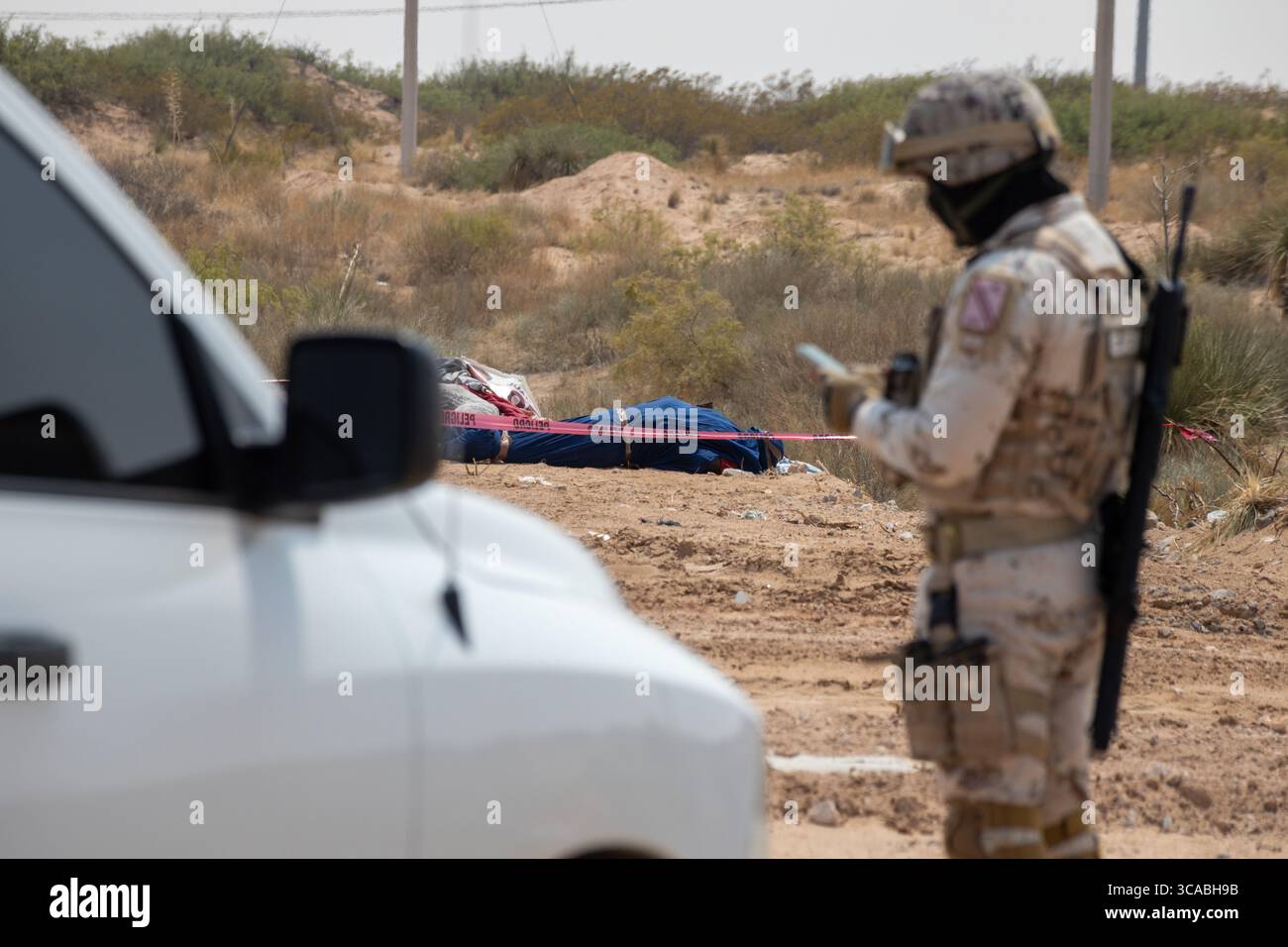 Un soldat inspecte une scène de crime dans le désert de Ciudad Juarez. Banque D'Images
