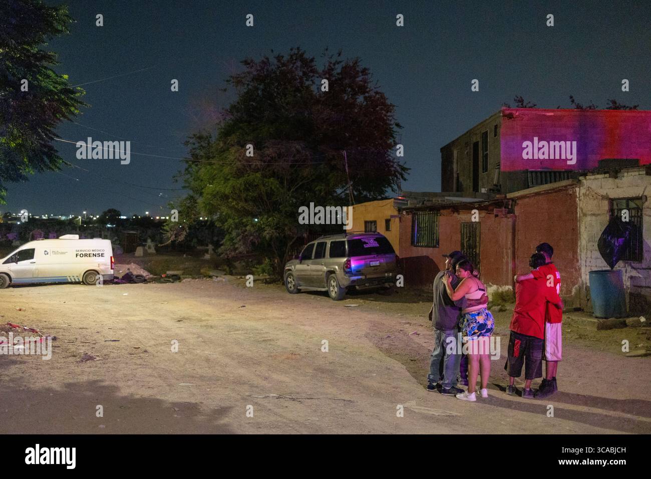 Les résidents se rassemblent sous les lampadaires d'une camionnette de criminalistique à Ciudad Juarez, soulignant les problèmes de violence urbaine en cours. Banque D'Images