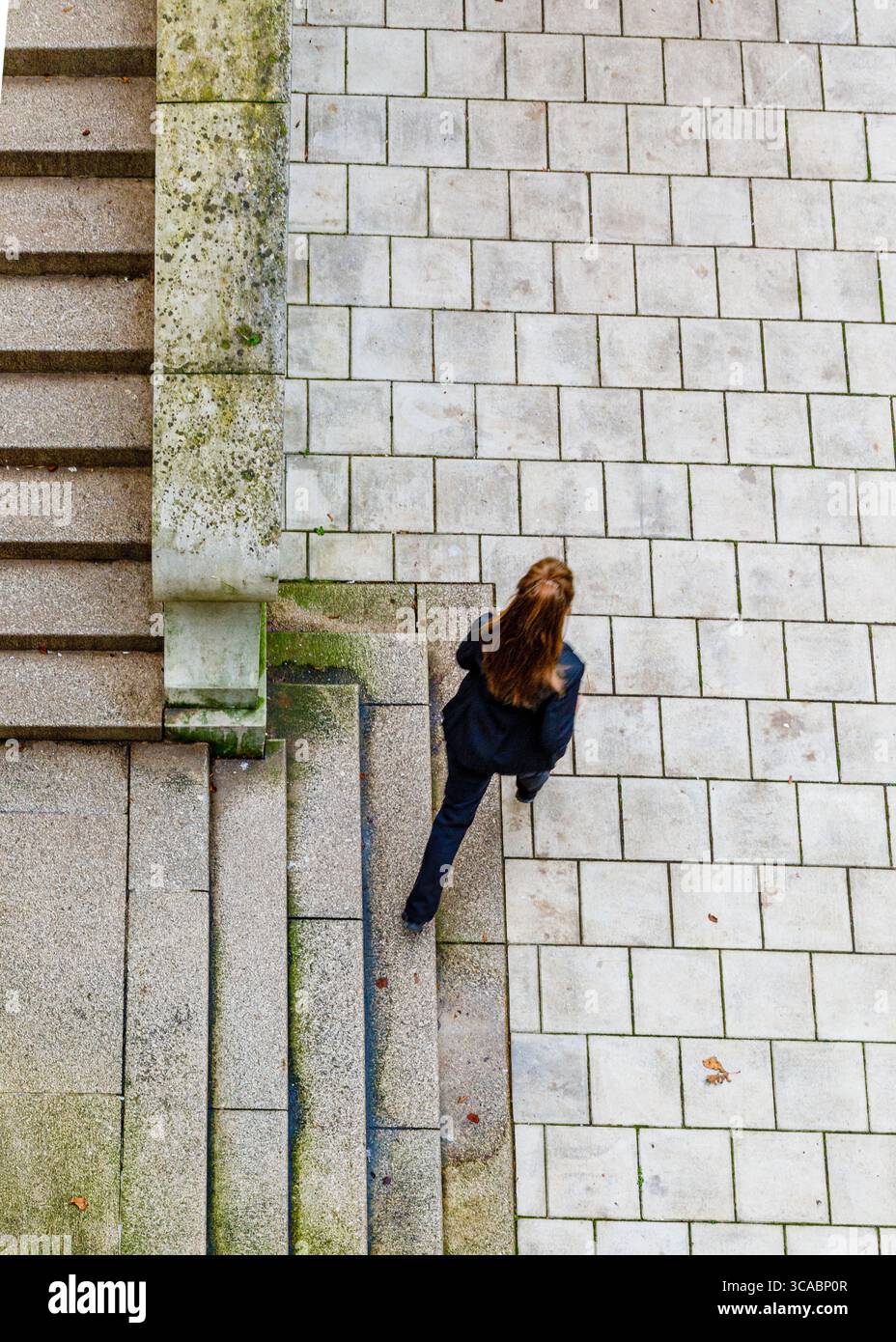 Une personne en costume noir descend un escalier. Banque D'Images
