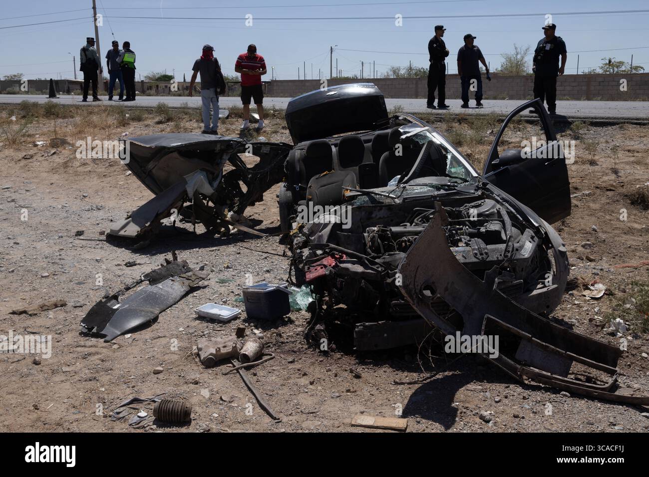 Voiture naufragée à Ciudad Juarez, un rappel brutal de la violence urbaine, avec la police et les habitants sur les lieux. Banque D'Images