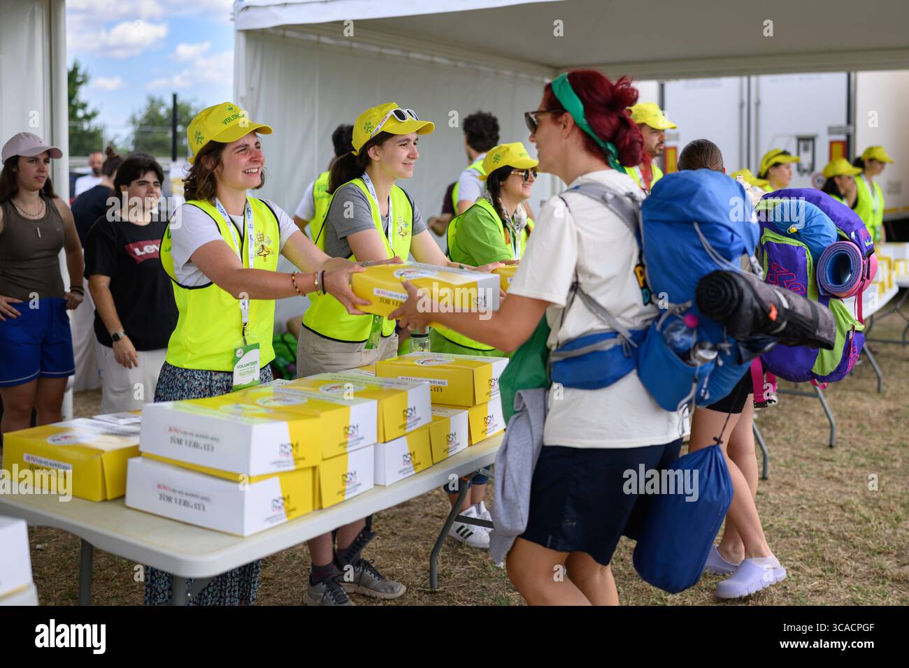 Des bénévoles distribuent des boîtes de nourriture à Tor Vergata pendant le Jubilé de la Jeunesse avec le Pape Léon XIV à Rome, en Italie. Banque D'Images