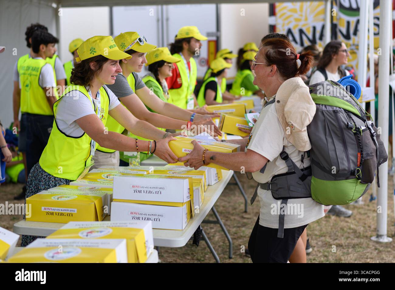 Des bénévoles distribuent des boîtes de nourriture à Tor Vergata pendant le Jubilé de la Jeunesse avec le Pape Léon XIV à Rome, en Italie. Banque D'Images