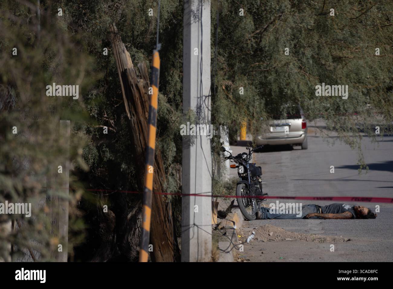 Un homme handicapé par la violence urbaine à Ciudad Juarez est allongé à côté de sa moto. Banque D'Images