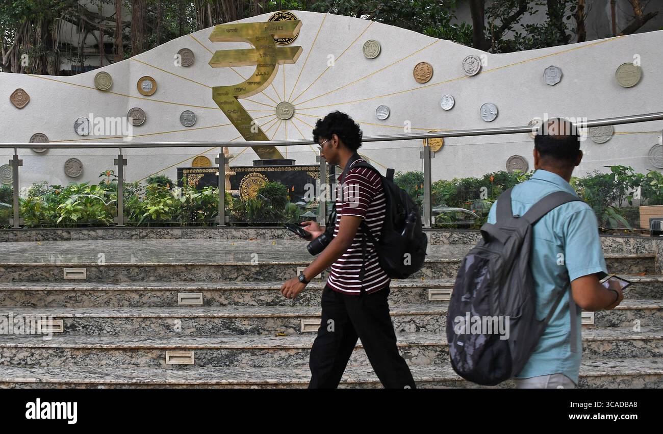 Mumbai, Maharashtra, Inde. 6 août 2025. Les gens passent devant une installation de symboles de roupies devant le bâtiment de la Reserve Bank of India (RBI) à Mumbai. Le symbole de la roupie est la monnaie officielle de l'Inde utilisée dans toutes les transactions financières de biens et services à travers le pays. (Crédit image : © Ashish Vaishnav/SOPA images via ZUMA Press Wire) USAGE ÉDITORIAL SEULEMENT ! Non destiné à UN USAGE commercial ! Banque D'Images