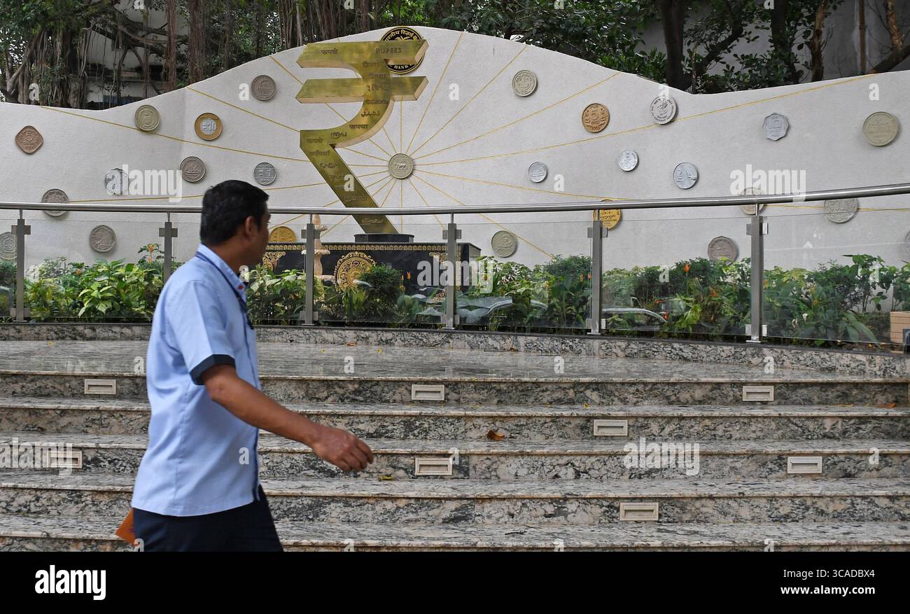 Mumbai, Maharashtra, Inde. 6 août 2025. Un homme passe devant une installation de symboles de roupies devant le bâtiment de la Reserve Bank of India (RBI) à Mumbai. Le symbole de la roupie est la monnaie officielle de l'Inde utilisée dans toutes les transactions financières de biens et services à travers le pays. (Crédit image : © Ashish Vaishnav/SOPA images via ZUMA Press Wire) USAGE ÉDITORIAL SEULEMENT ! Non destiné à UN USAGE commercial ! Banque D'Images