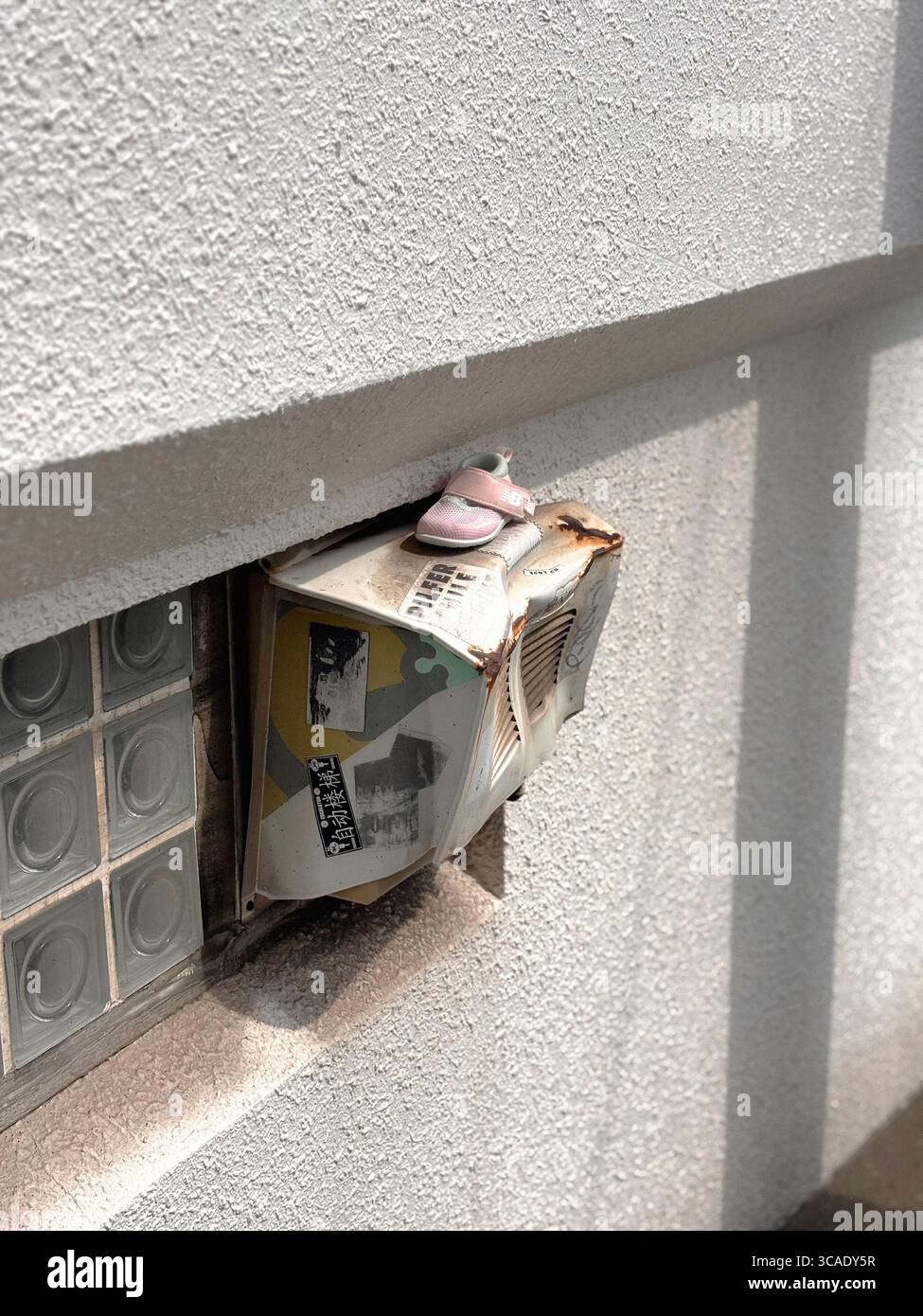 Chaussure de bébé rose perdue sur une boîte aux lettres bosselée à Nakameguro, Tokyo Banque D'Images