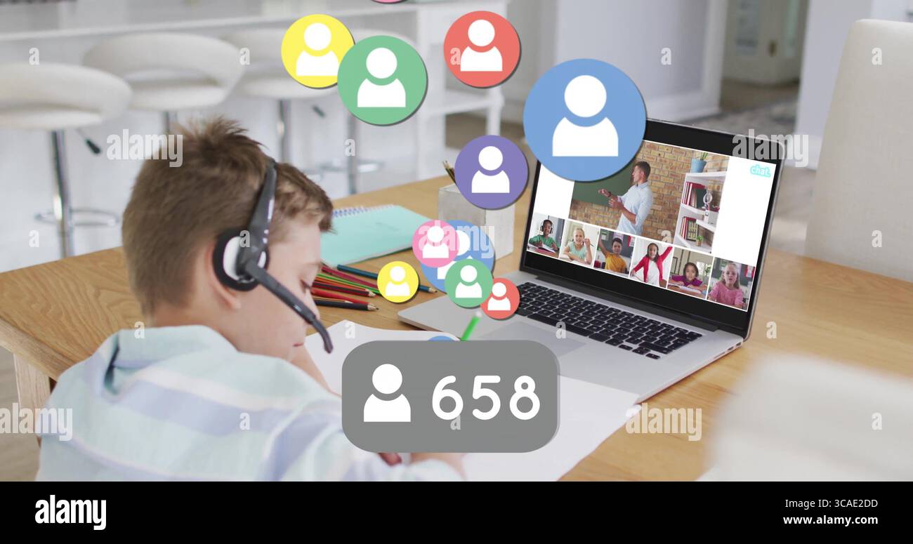 Fin de l'activité, l'élève porte un casque-micro rayé à l'aide d'un ordinateur portable, des crayons à la table de la cuisine Banque D'Images