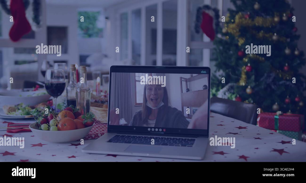 Affichage de la femme surprise sur l'écran d'ordinateur portable pendant le repas de vacances avec bol de fruits et arbre de Noël Banque D'Images