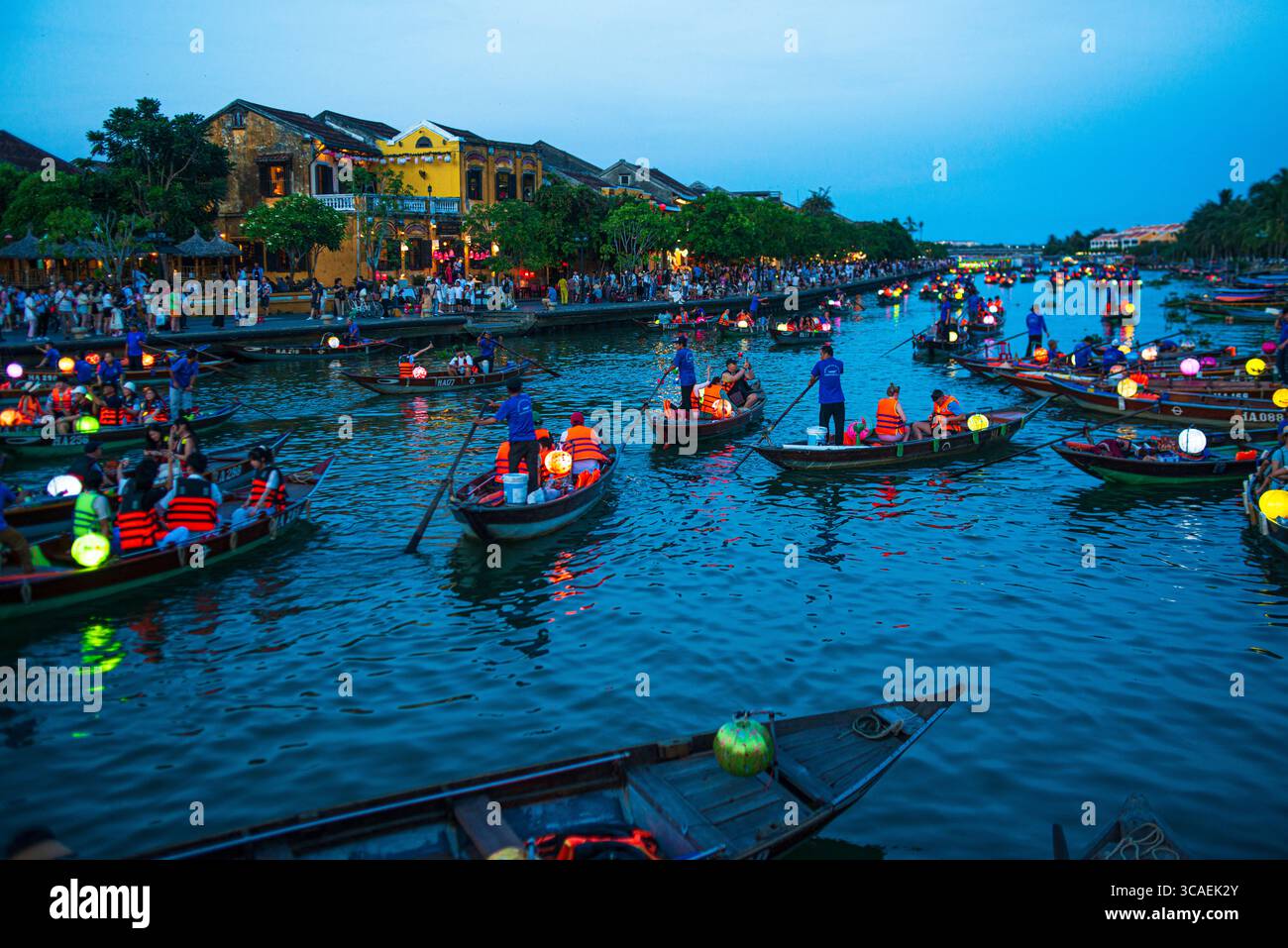 Hoi an, Vietnam – 15 juin 2024 : les touristes apprécient les promenades traditionnelles en bateau éclairées par des lanternes le long de la rivière Thu bon au crépuscule dans la vieille ville de Hoi an. Ce vibran Banque D'Images