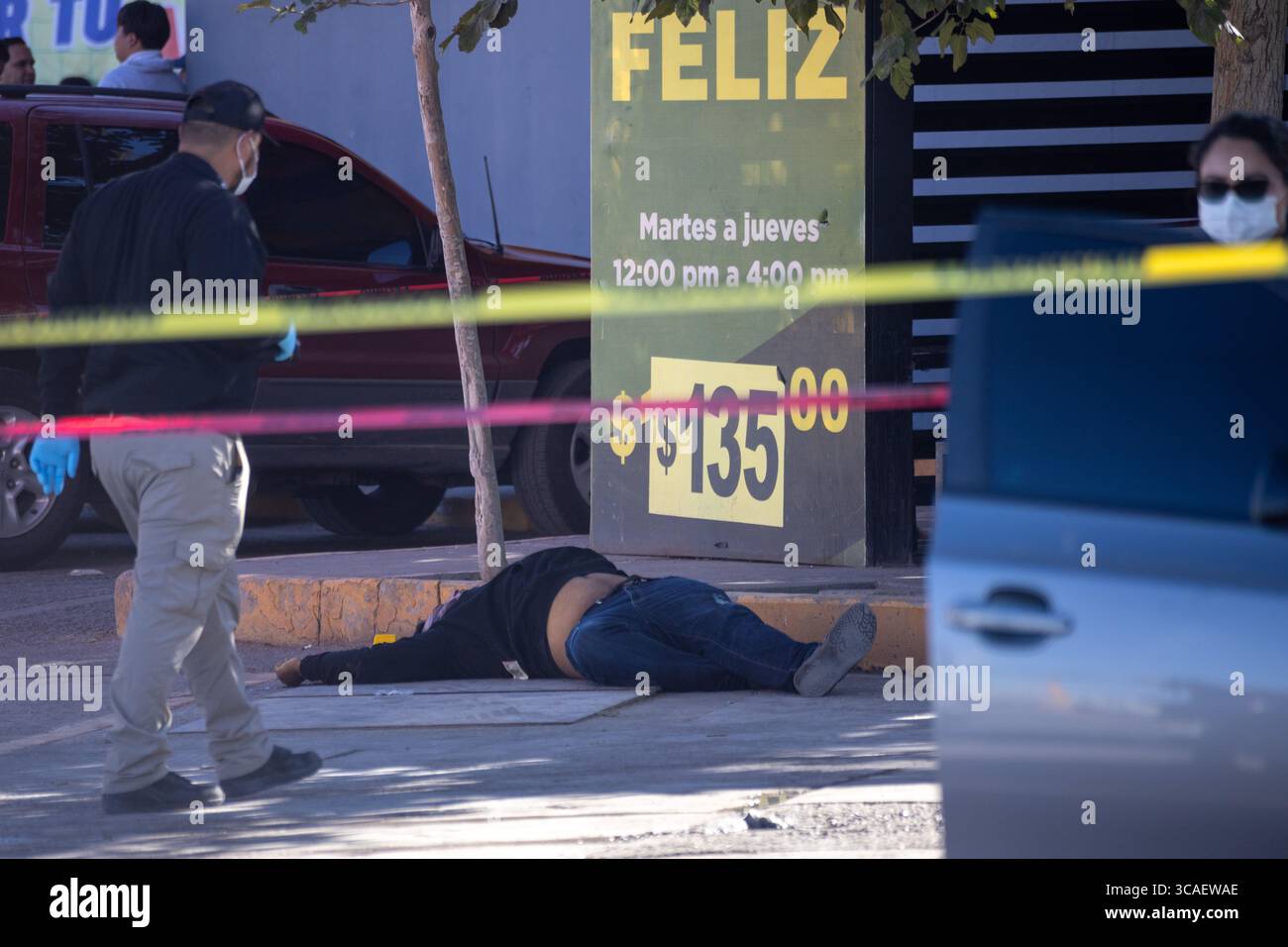 Une scène tragique à Ciudad Juarez avec un corps au milieu de la bande de police et de scène de crime, soulignant les problèmes de violence urbaine. Banque D'Images