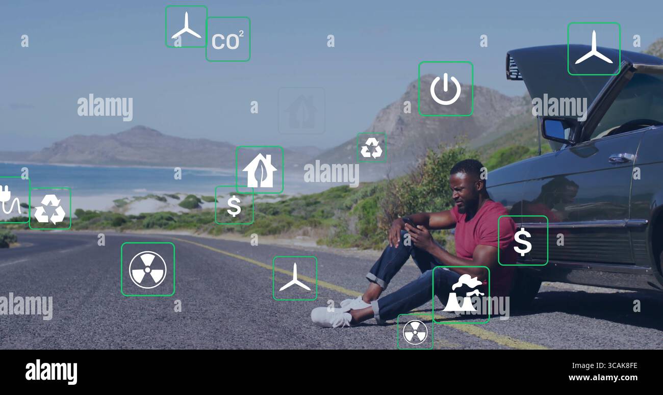 Homme de vérification portant T-shirt rouge tenant smartphone sur la route côtière, capot de voiture ouvert, espace de copie Banque D'Images