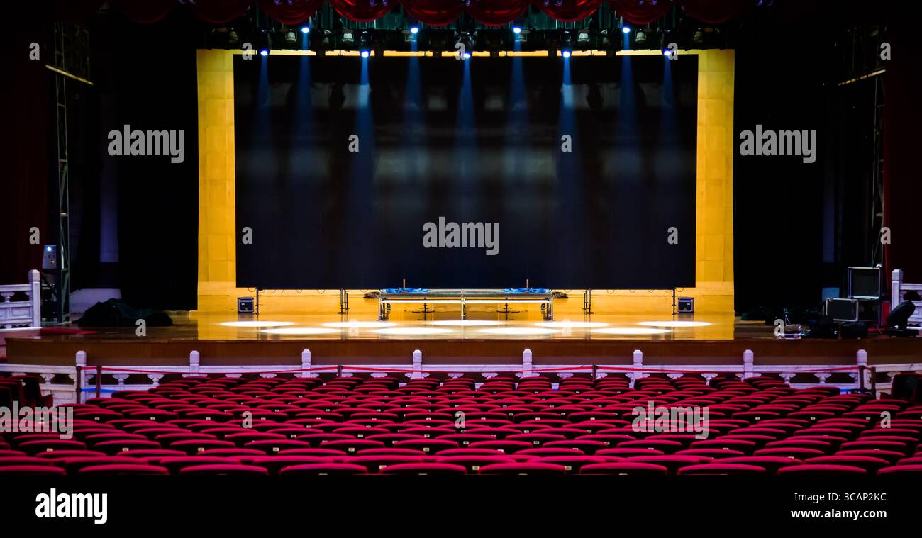 Salle de concert ou de spectacle. Sièges rouges fauteuils et la scène avant concert Banque D'Images