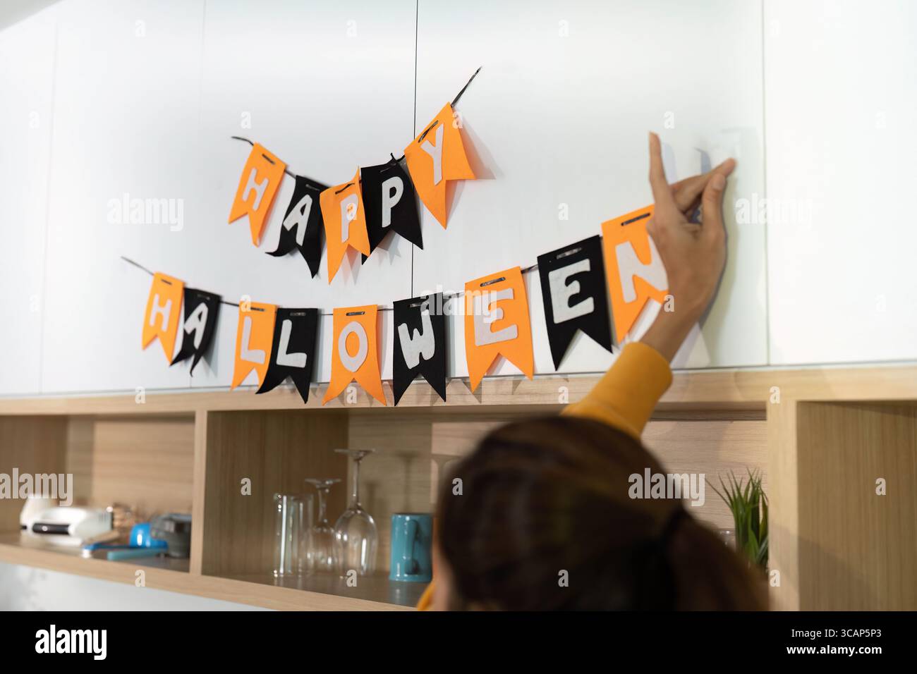 Célébration d'Halloween. Maison décorée avec des bannières festives et un enfant se préparant à un tour ou à un traitement. Banque D'Images