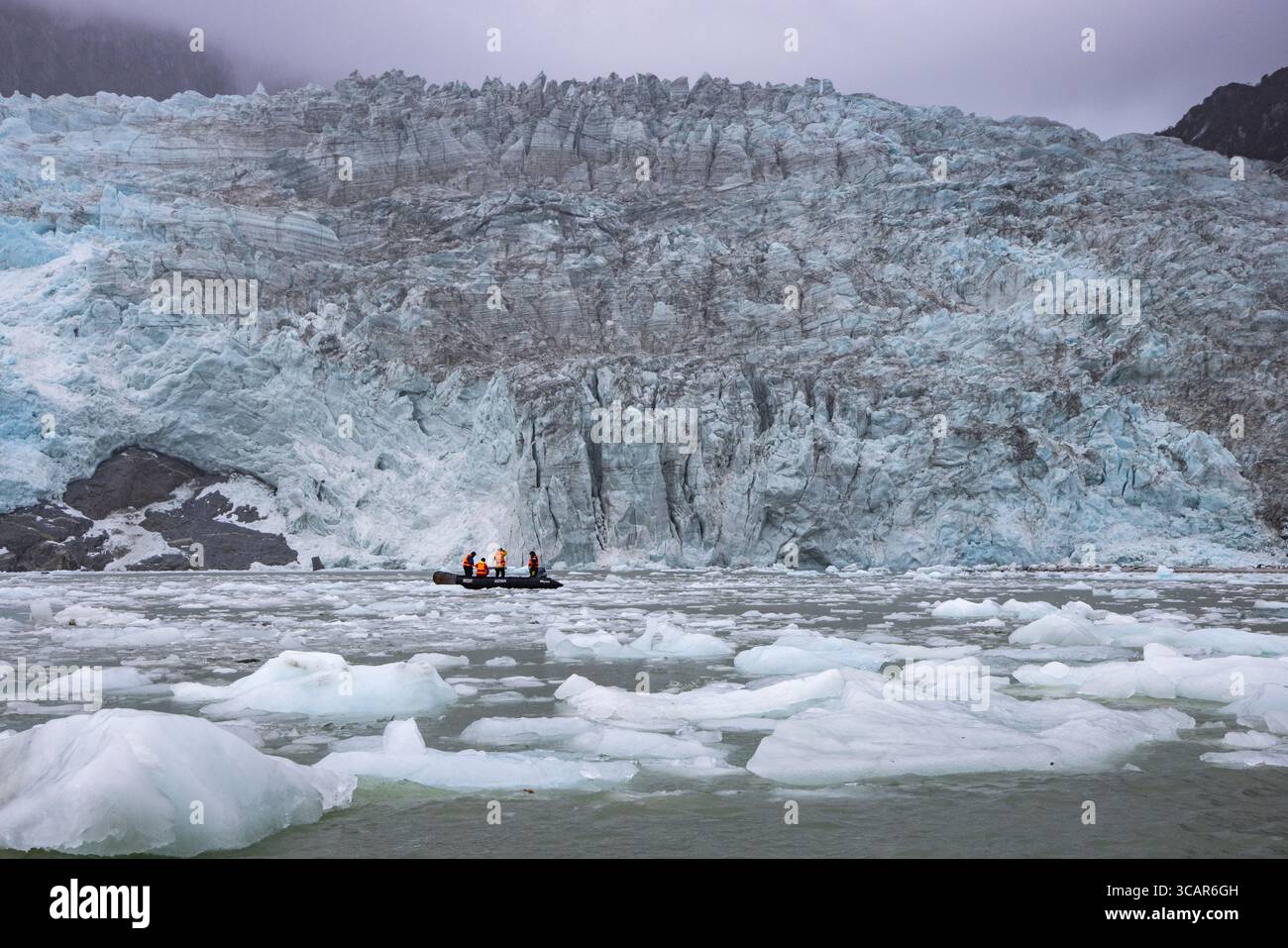 Bateau Zodiac du navire de croisière d'expédition Ventus Australis (Australis Cruises) devant le glacier Pio X avec des banquises au premier plan, Eyre Banque D'Images