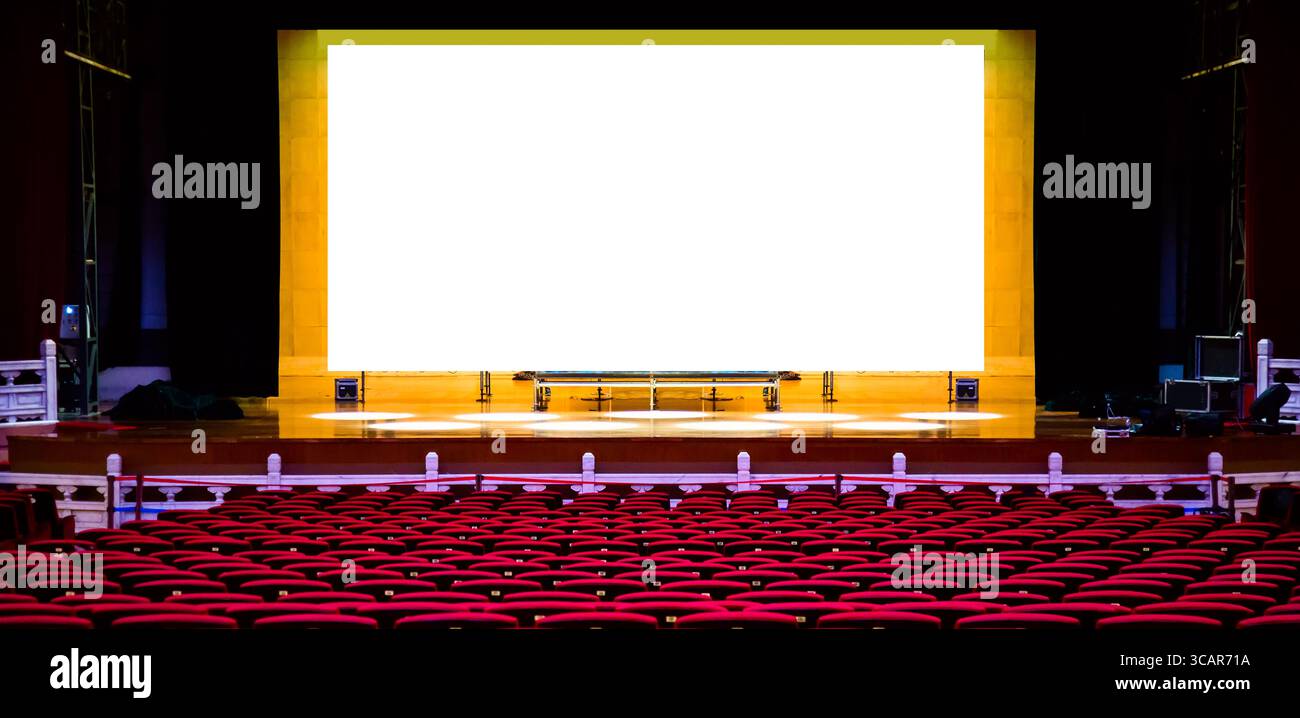 Salle de concert ou de spectacle. Sièges rouges fauteuils et la scène avant concert avec écran blanc vierge. Maquette de conception. Banque D'Images