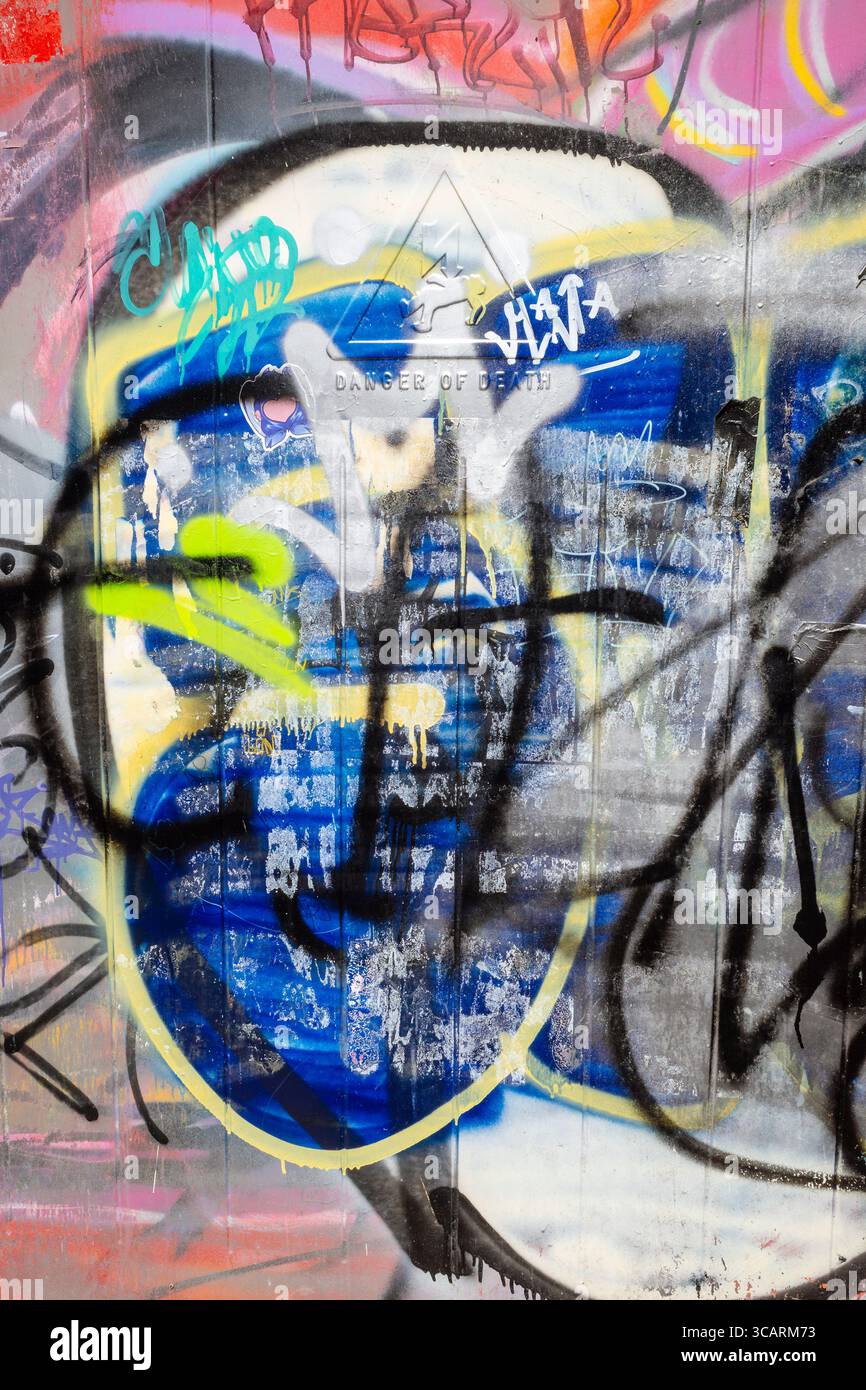 Gros plan gros plan de graffitis et d'étiquettes colorés laides pulvérisés sur le couvercle métallique d'une sous-station électrique à Newquay en Cornouailles au Royaume-Uni. Banque D'Images
