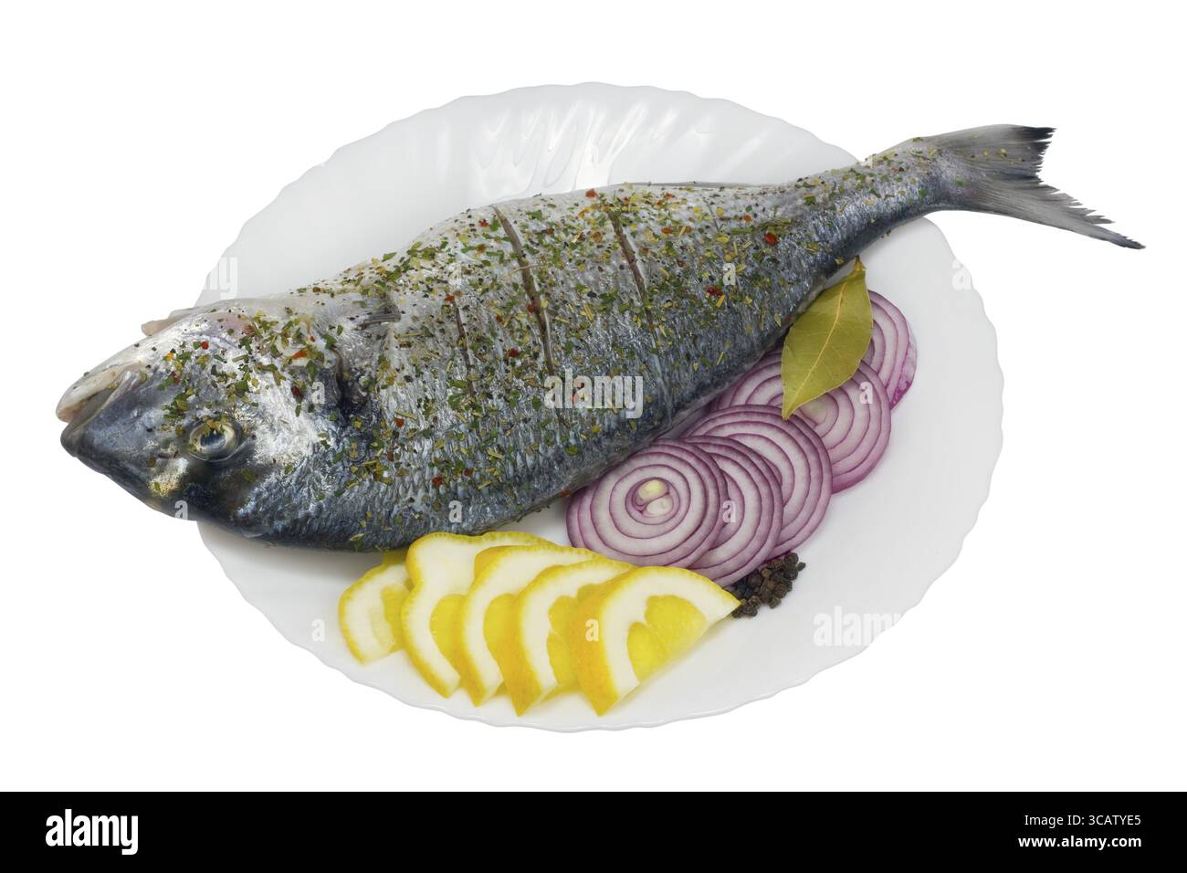 Le poisson de mérou frais (Dolphin, Dorado) sur une plaque de céramique blanche aux bords ondulés. Le poisson est préparé pour la torréfaction - est arrosé avec un citron, salé Banque D'Images