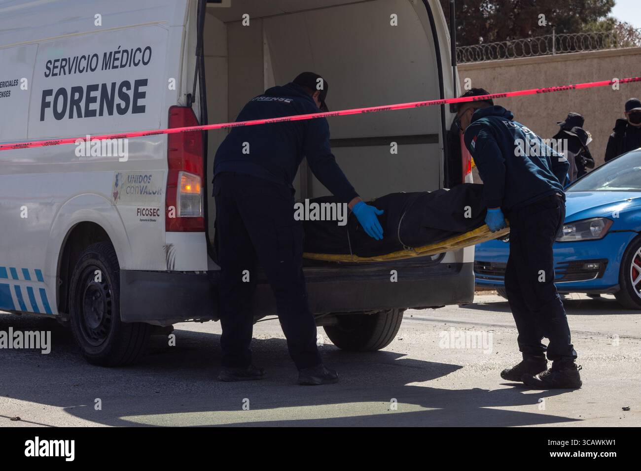 L'équipe médico-légale de Ciudad Juarez charge un corps dans une camionnette sur une scène de crime, reflétant la lutte continue de la ville contre la violence urbaine. Banque D'Images