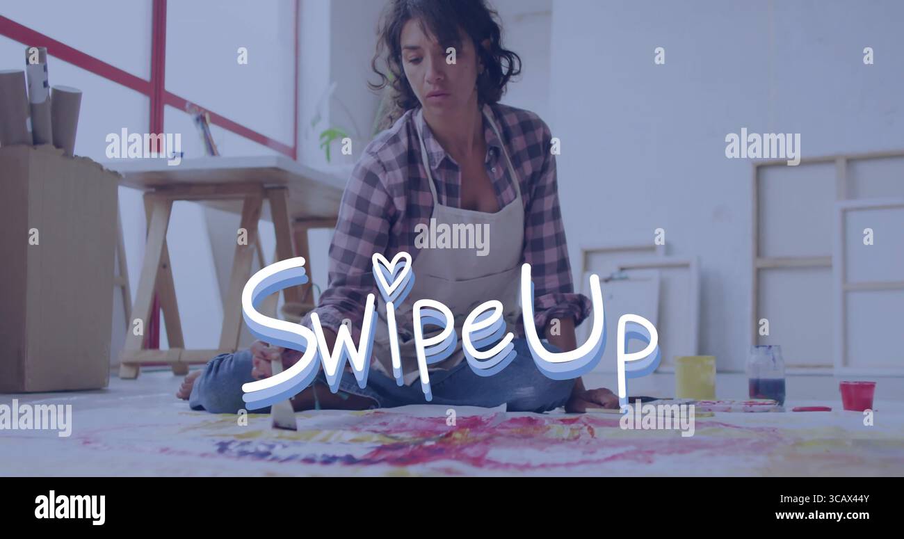 Peinture artiste féminine portant tablier appliquer de la peinture vibrante sur la toile sur le sol du studio, avec des pots Banque D'Images