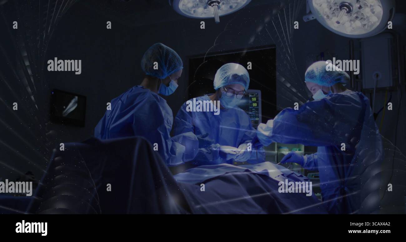 Chirurgie pratiquant l'équipe chirurgicale portant des blouses opérant dans LE BLOC OPÉRATOIRE, avec des lumières et une table chirurgicale Banque D'Images