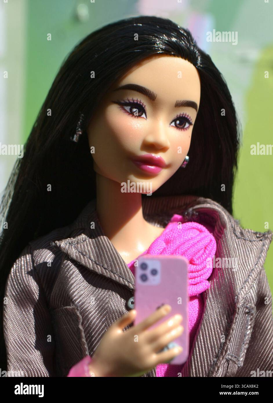 Poupée asiatique Deluxe Barbie sur son téléphone portable Banque D'Images